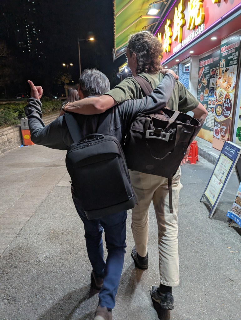 Two men walking down the street with backpacks, showing off a simple and practical alternative to a traditional nappy bag.
